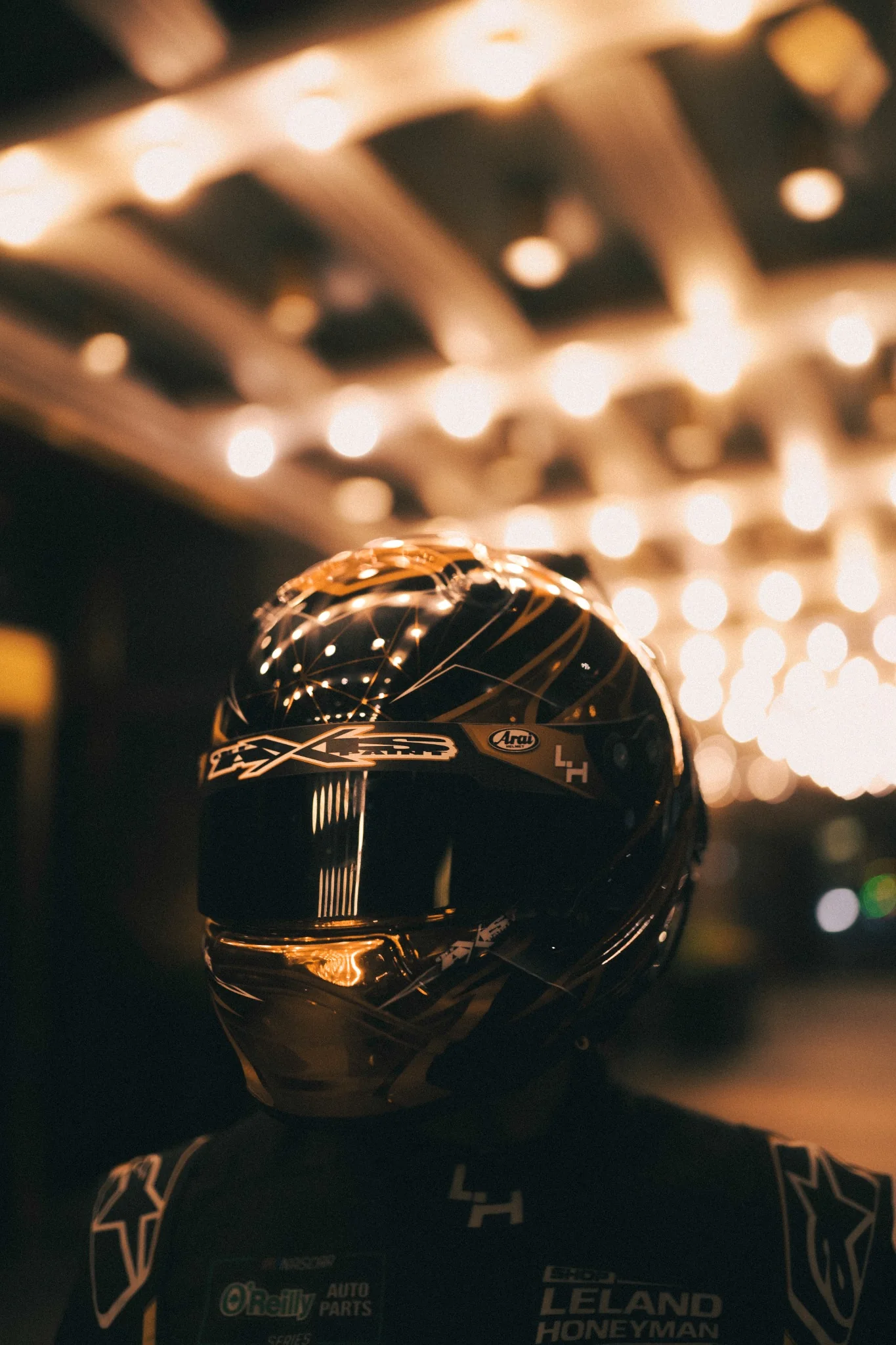 Cinematic portrait of a helmeted race driver under warm lights