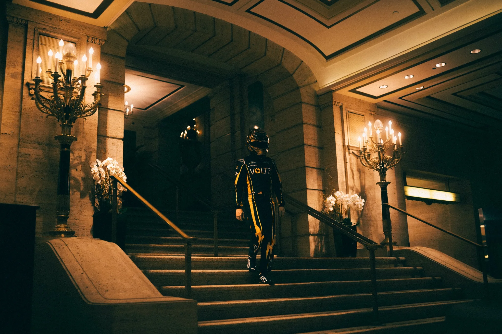 Race driver walking through a grand hotel lobby