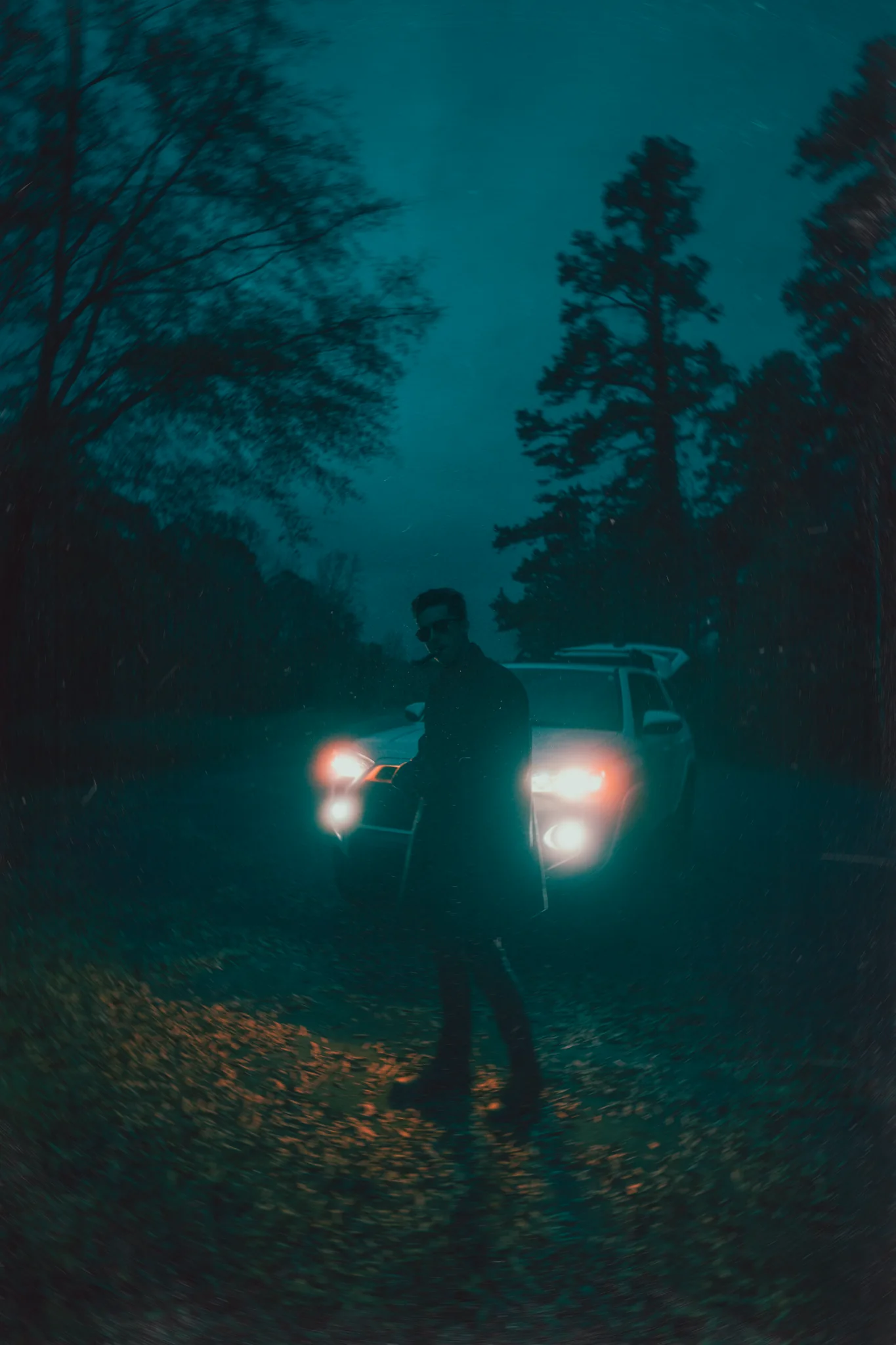 Moody night portrait in front of car headlights