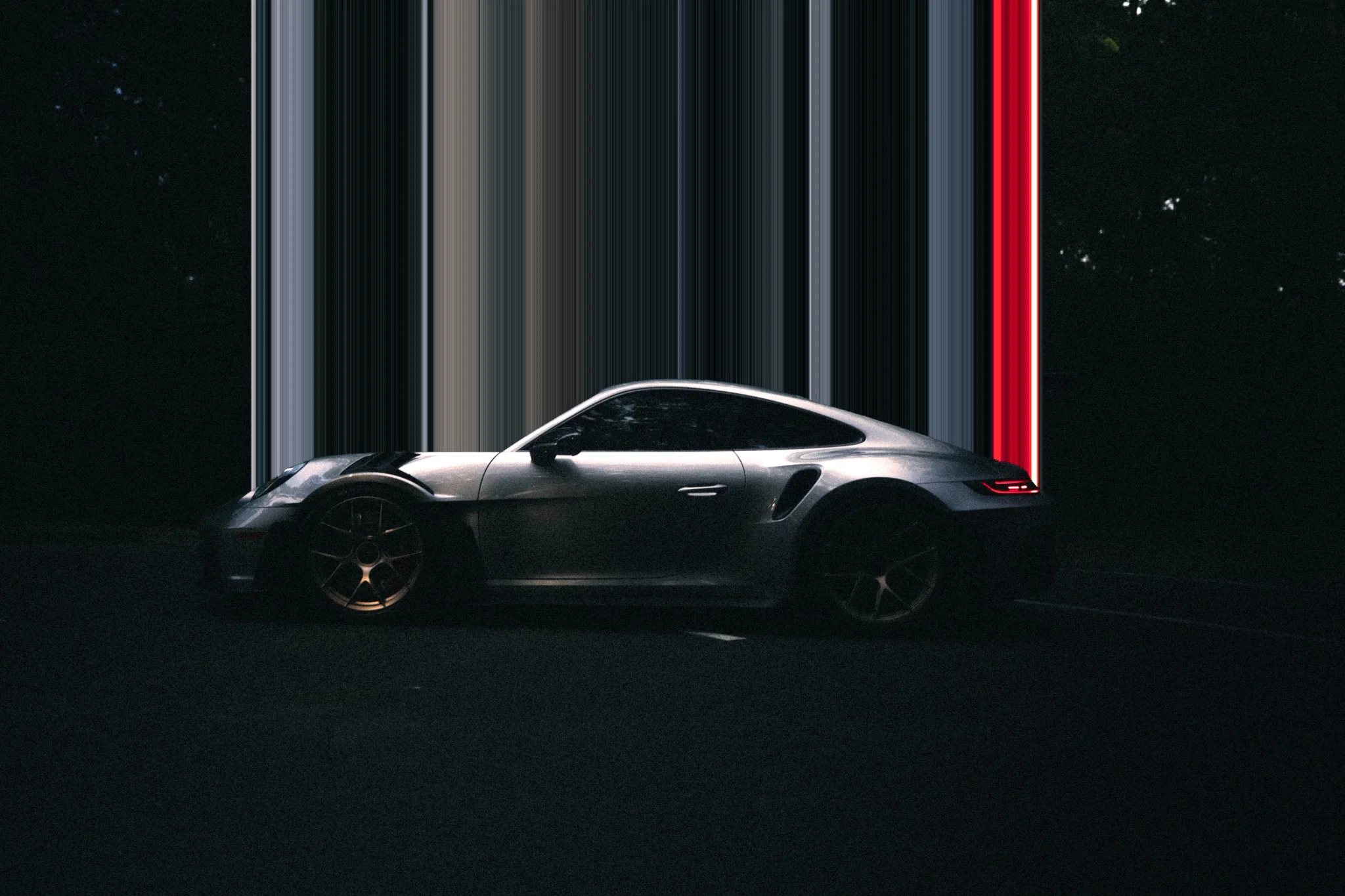 Silver Porsche photographed against an abstract red-lit background